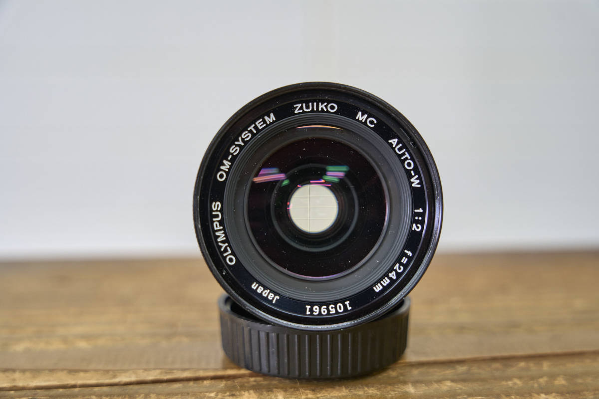 Olympus OM-System Zuiko Auto-W 24 mm F/2.8 +Filtre UV+Pare Soleil+ 2 Caps