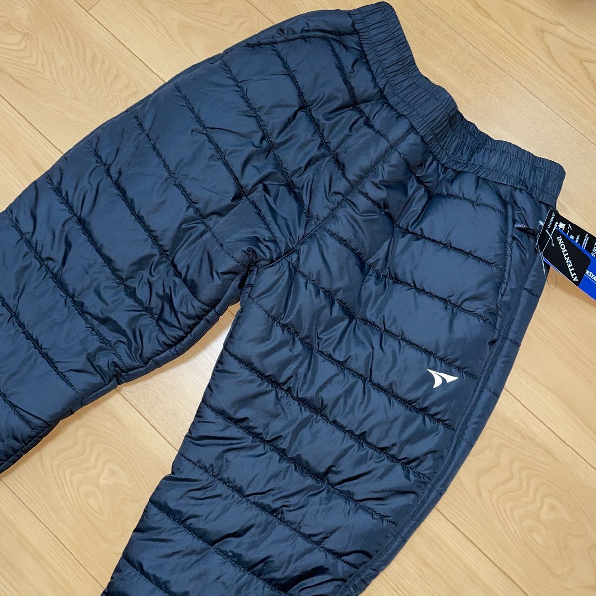 新品 TOURSTAGE ツアーステージ ゴルフ 撥水加工 中綿 ナイロンパンツ メンズLL 黒色 放電テープ使用 ウィンドブレーカーパンツ