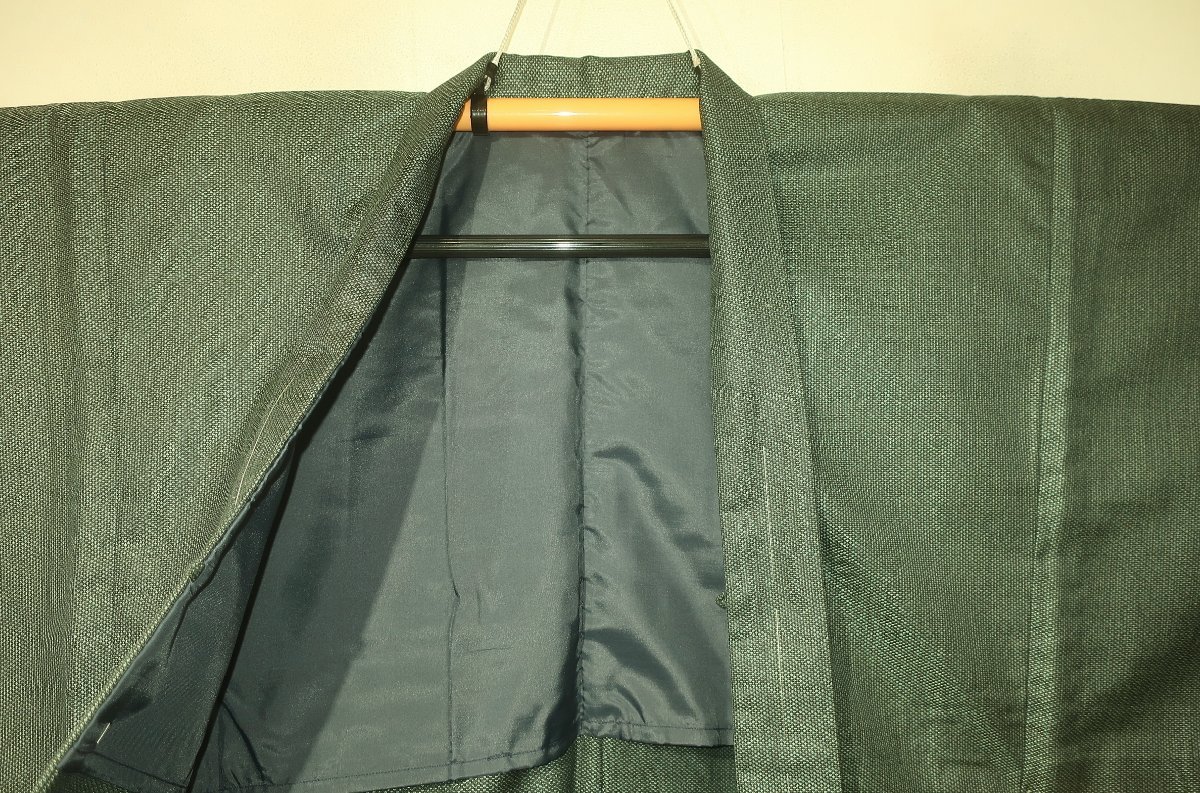 壱日4343 本絹交ぜ織伊勢崎お召調 男着物羽織 裄66丈141К青銅灰緑色濃淡梨地 未着用 正絹 男羽織 袷 -男性 孔雀青にピンクとアイボリーの小花と蝶・アイボリー袴（無地） 一般(男性和服、着物)の中古品